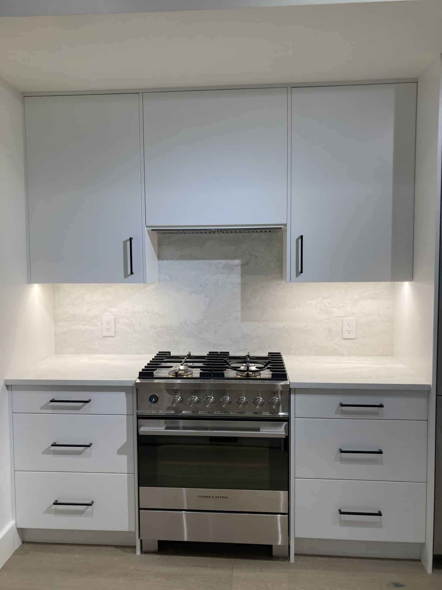 An oven and stove with white cabinets